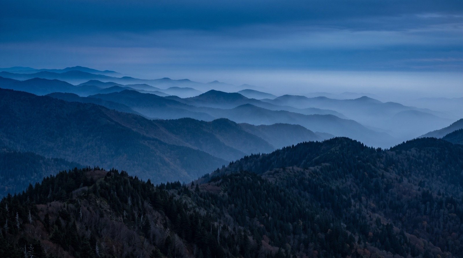 Layered blue mountain ridgelines in fog