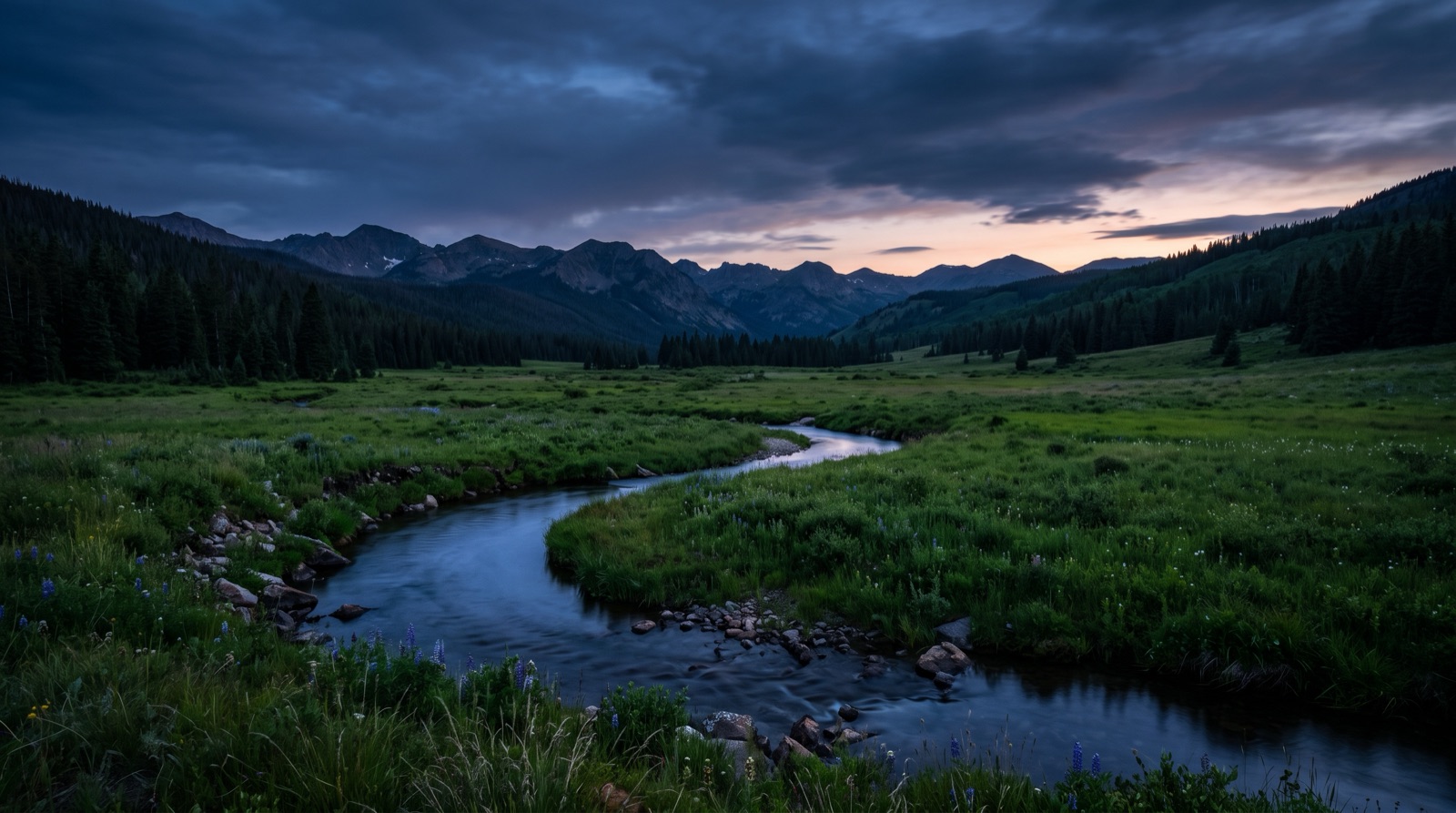 A spring creek through a green meadow