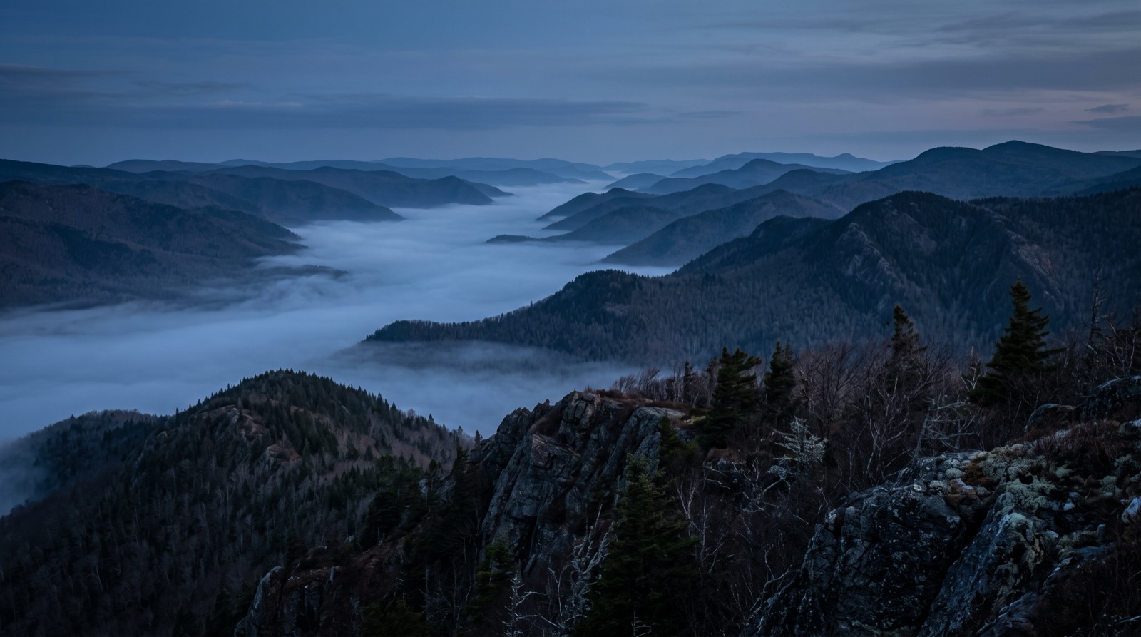 A fog-filled river valley from a ridge